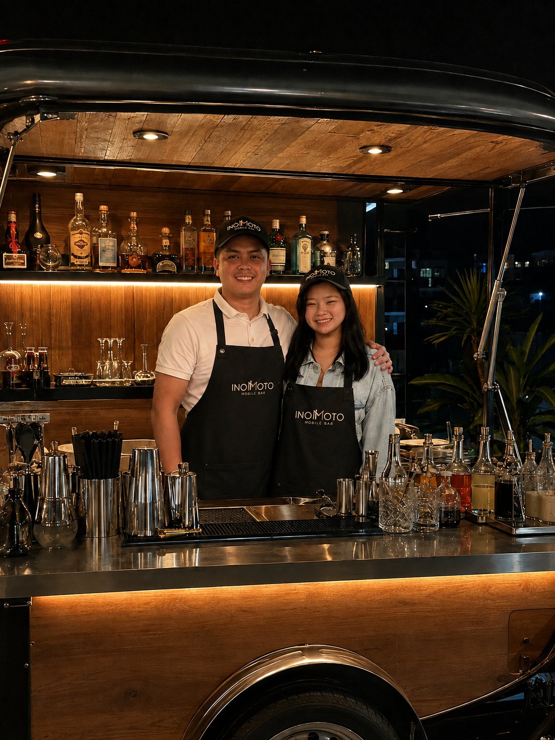 Inomoto bartenders smiling behind the mobile bar cart
